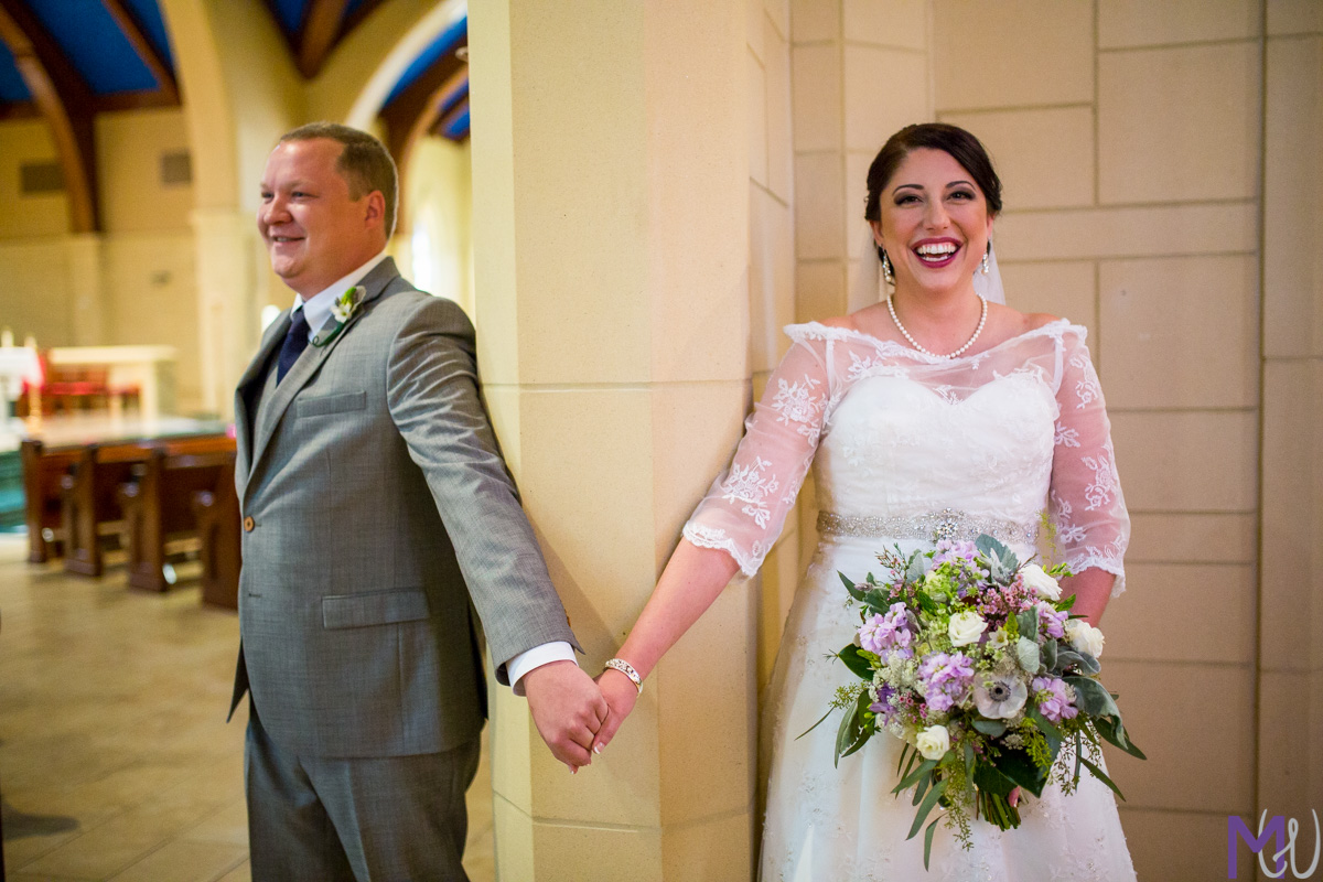 bride and groom hold hands around a door