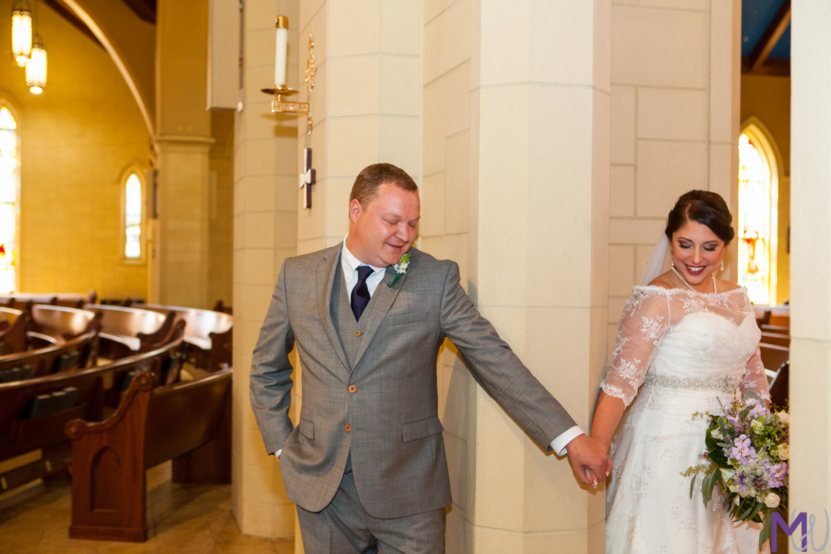 bride and groom hold hands around a door