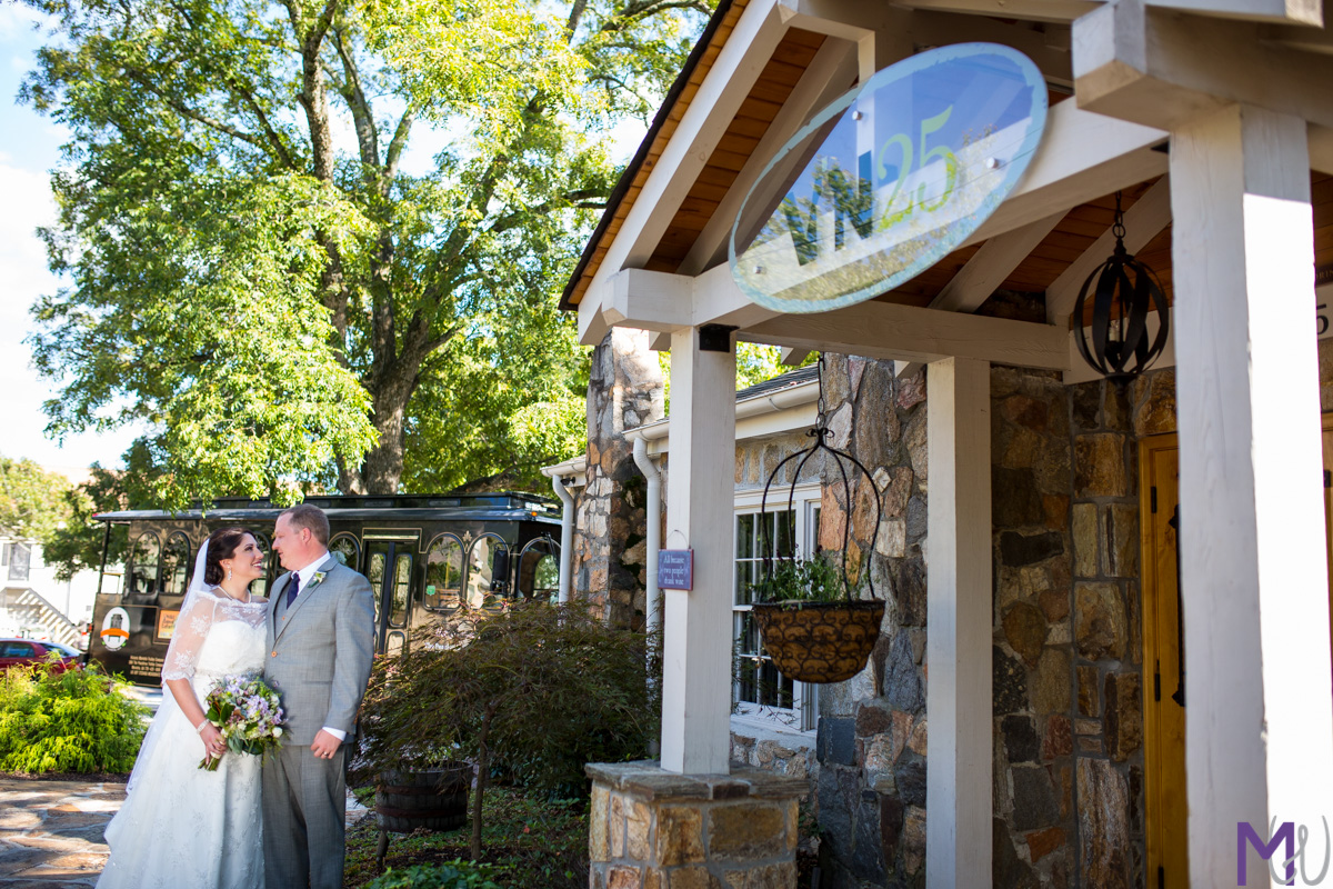 bride and groom kiss in front of grooms restaurant