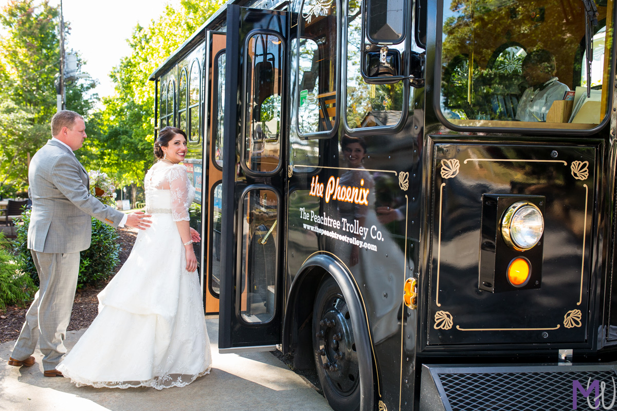 bride and groom get on a trolley