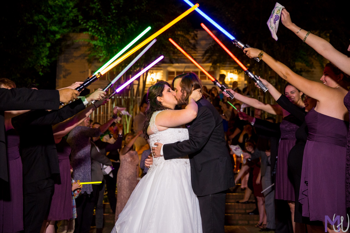 bride and groom exit under light sabers