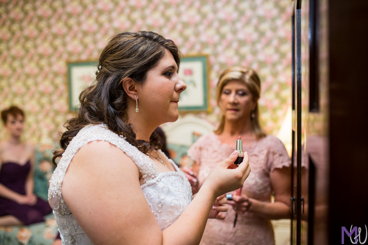 mother of the bride puts jewelry on the bride