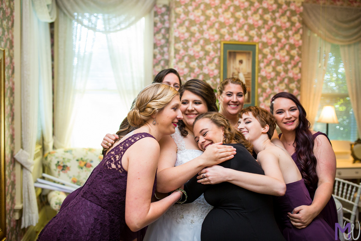 bridesmaids give bride a group hug