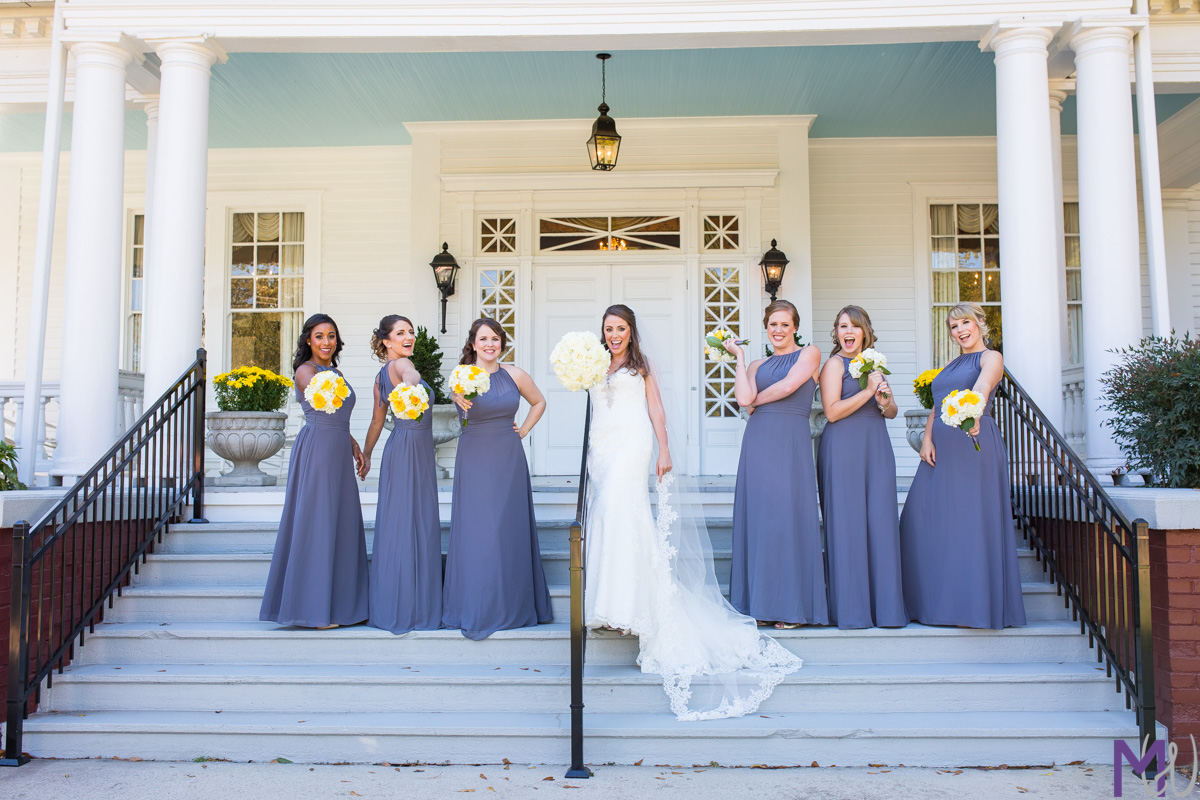bridesmaids in purple on colonial mansion stairs