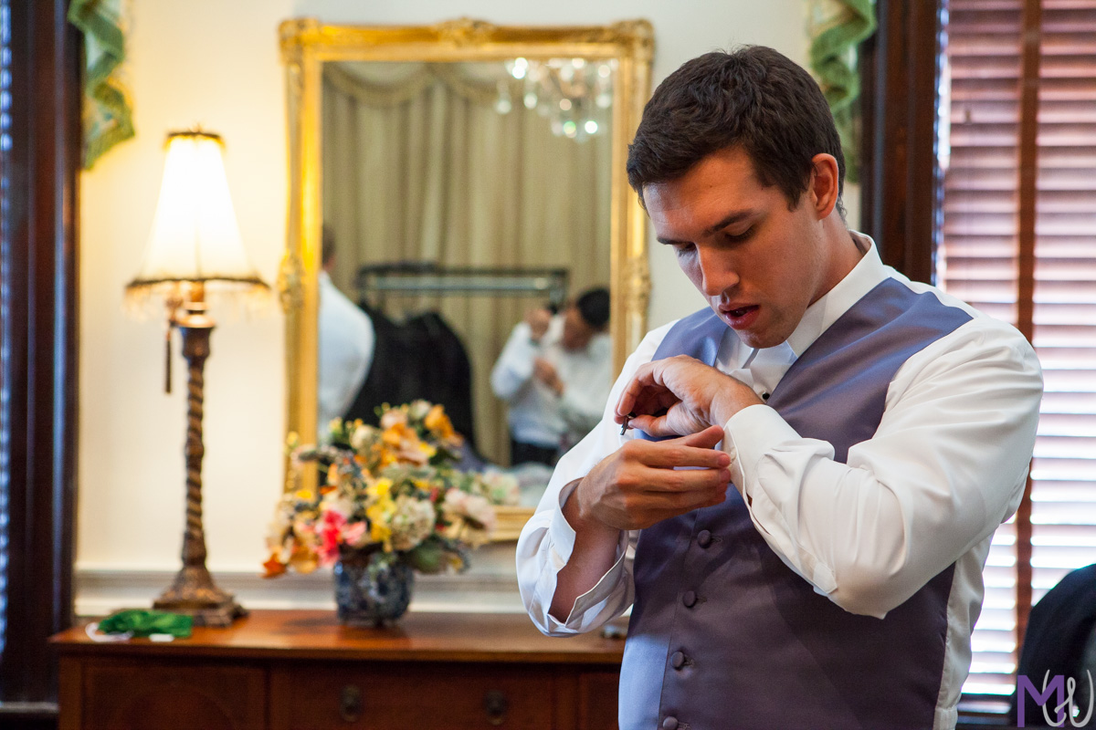 groom adjusts his cuff links