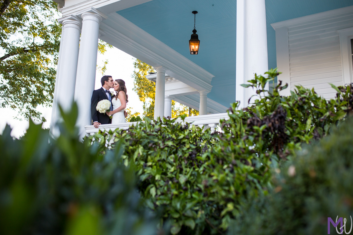 bride and groom kiss on front porch