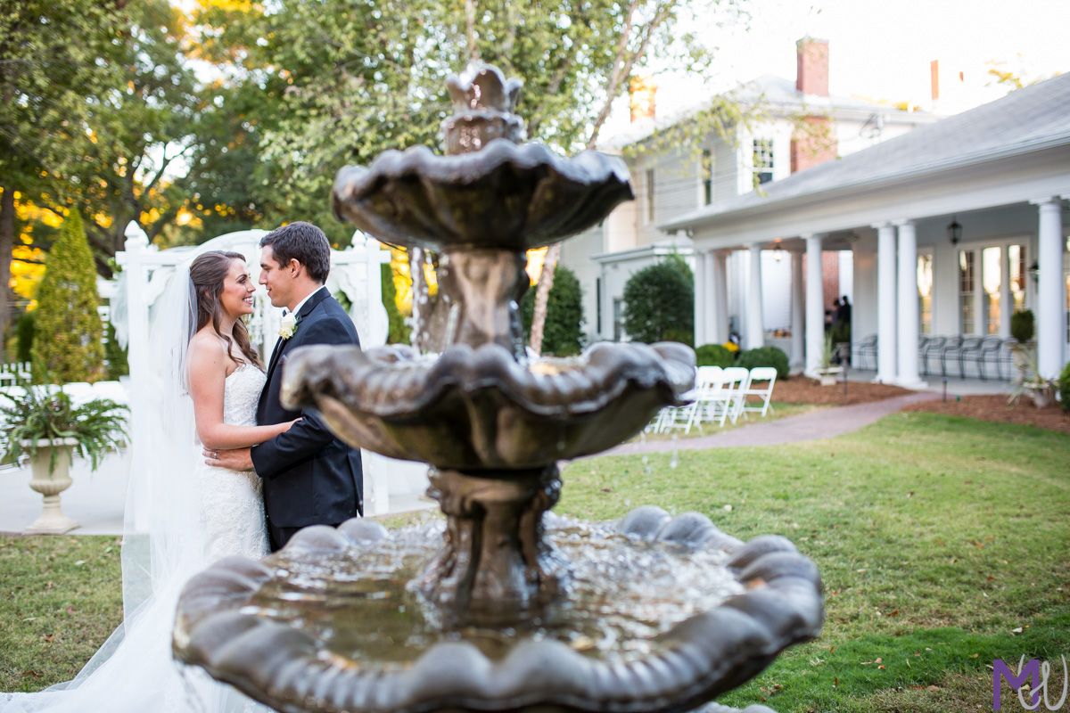 bride and groom next to a fountain