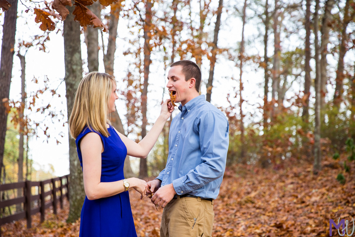 engagement photos laying in the fall leaves