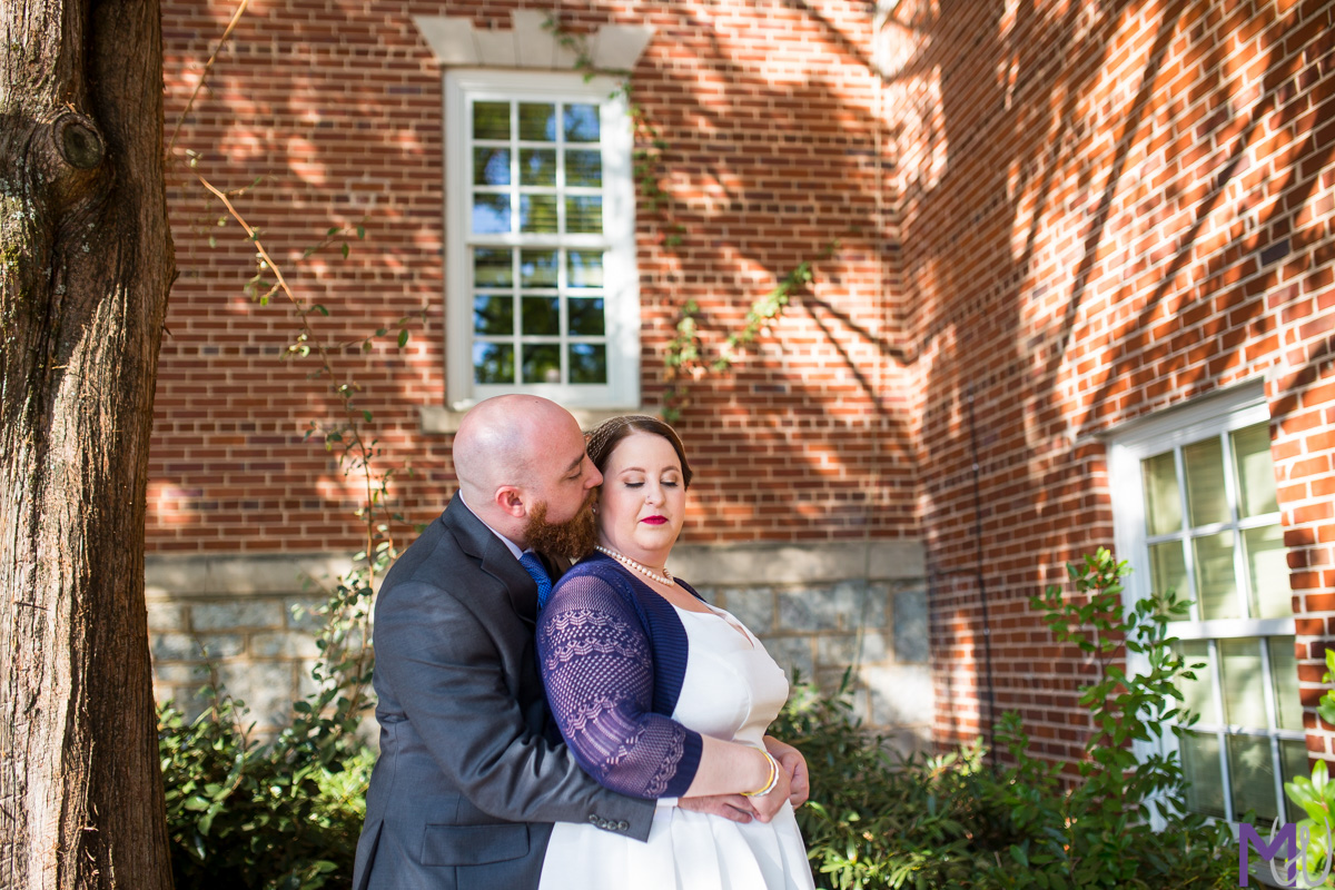 bride and groom in front of brick building