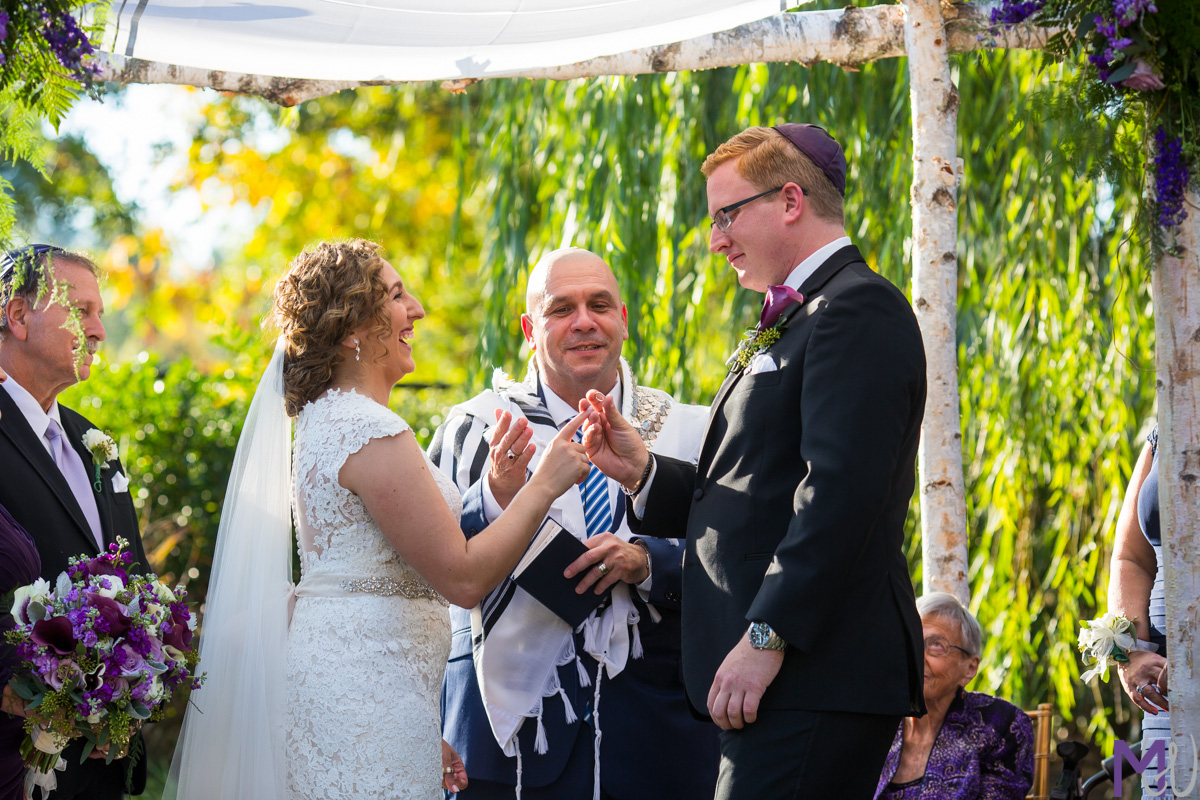 bride and groom exchange rings during jewish wedding ceremony