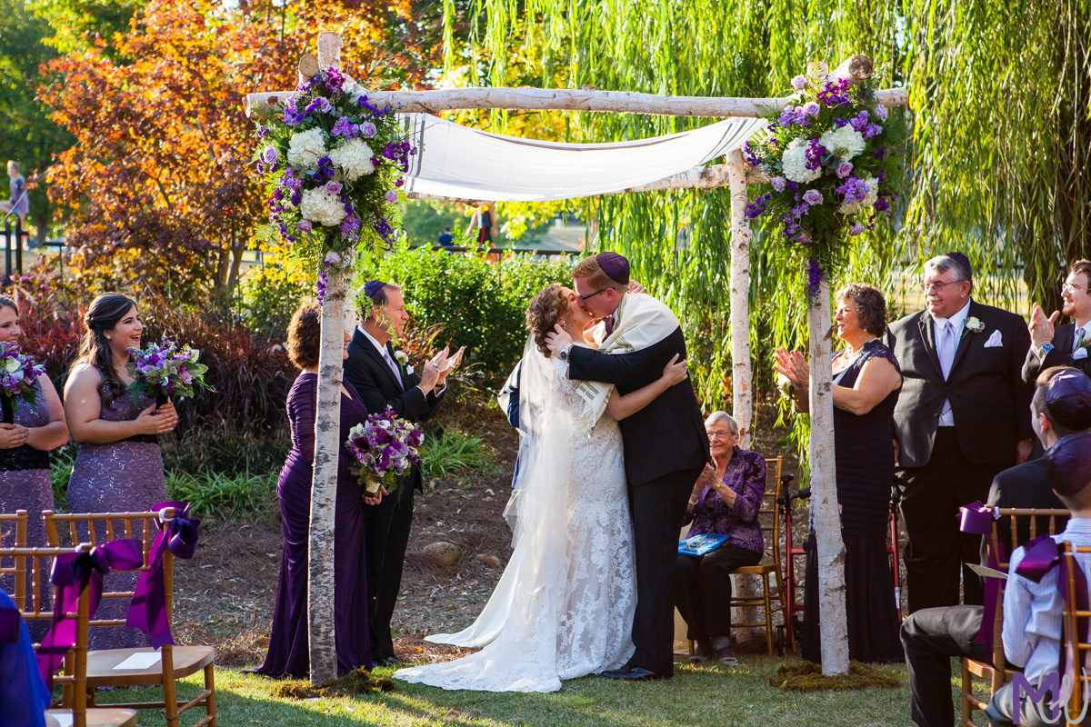 bride and groom share a first kiss at wedding ceremony