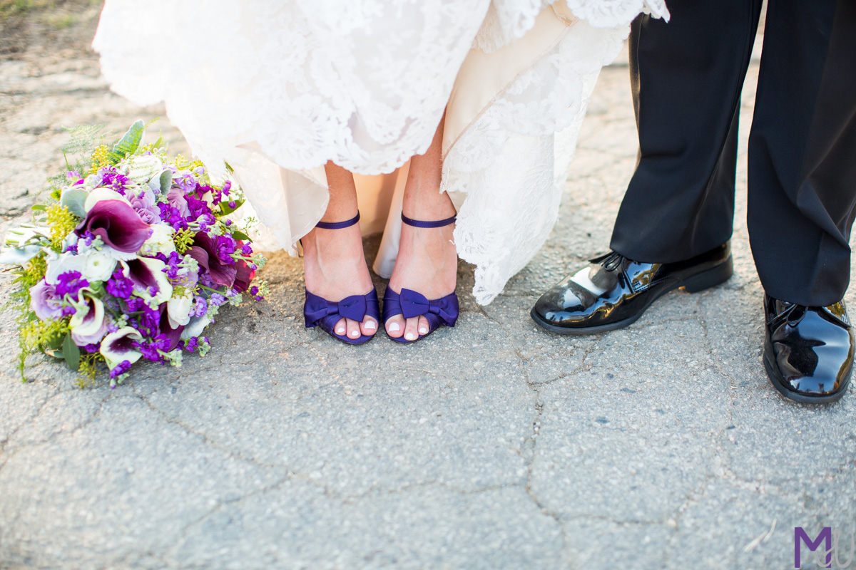 bride and grooms shoes with purple bouquet