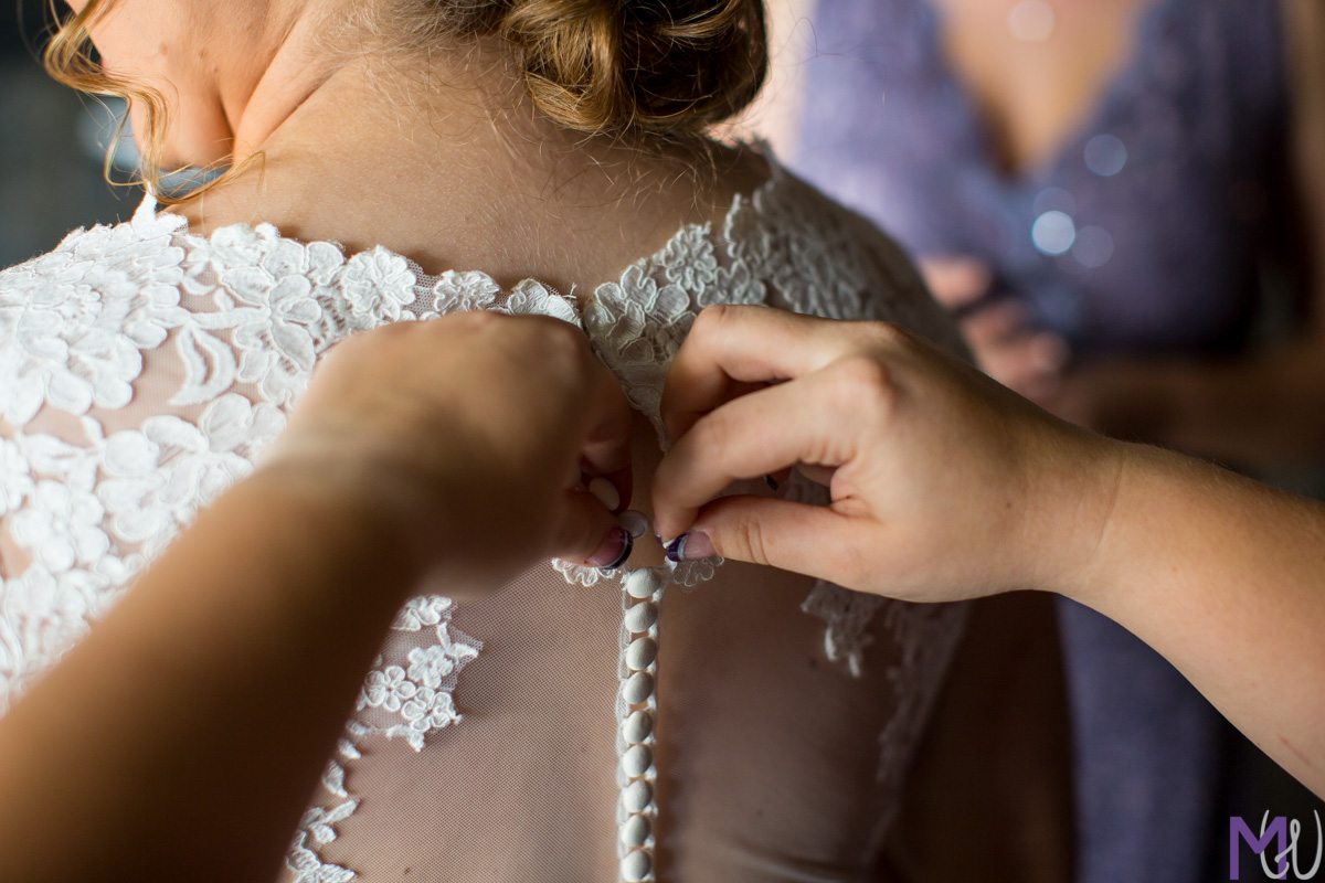 bride putting her wedding dress on
