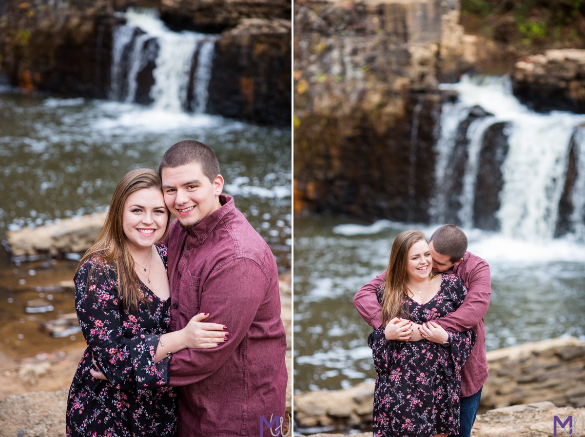 couple standing in front of a waterfall at freeman mill park