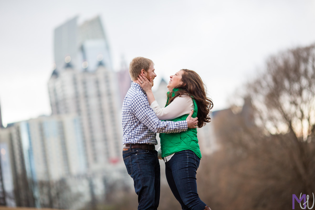 engaged couple in piedmont park with atlanta skyline view