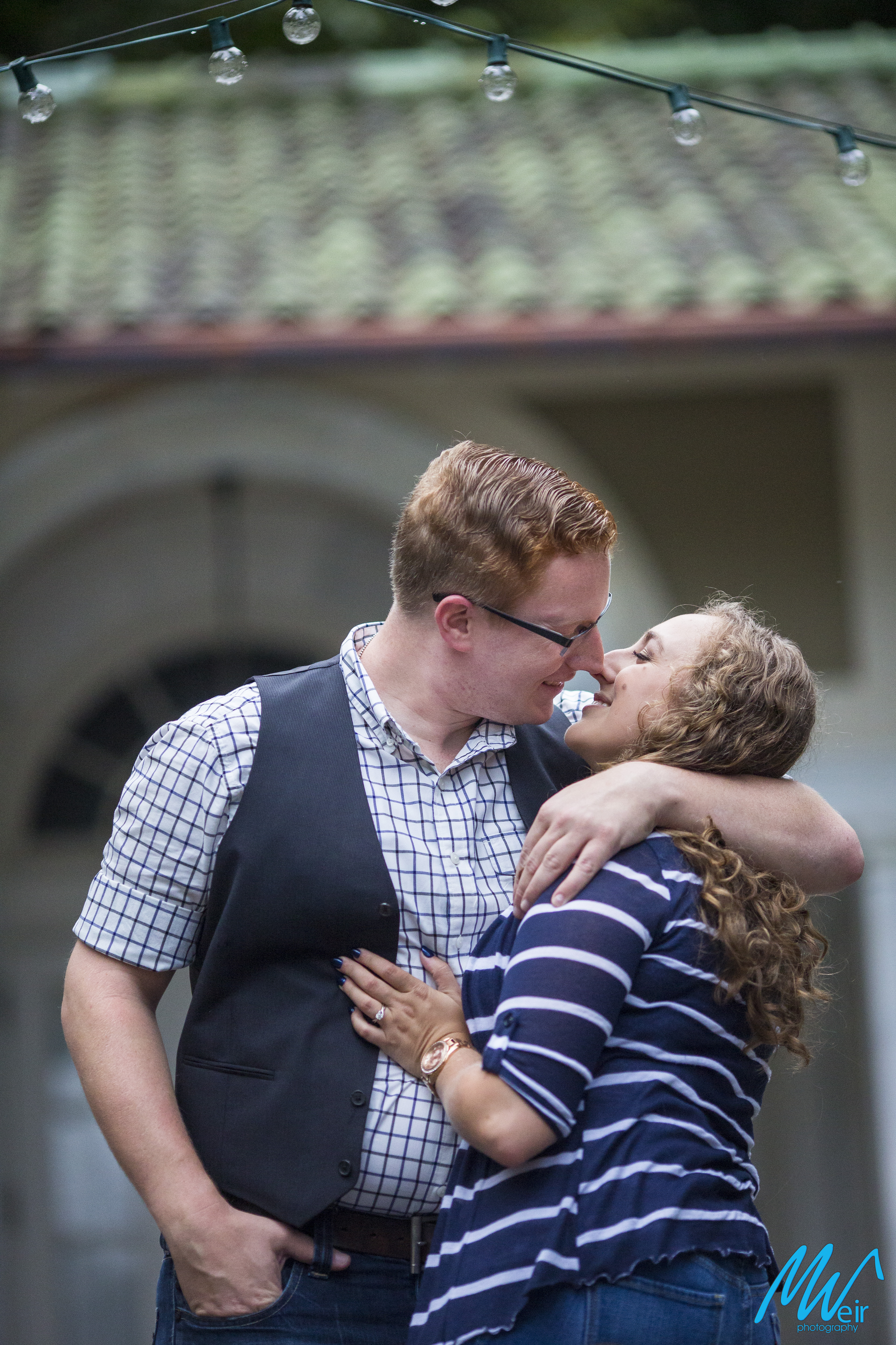 couple about to kiss in front of stone building