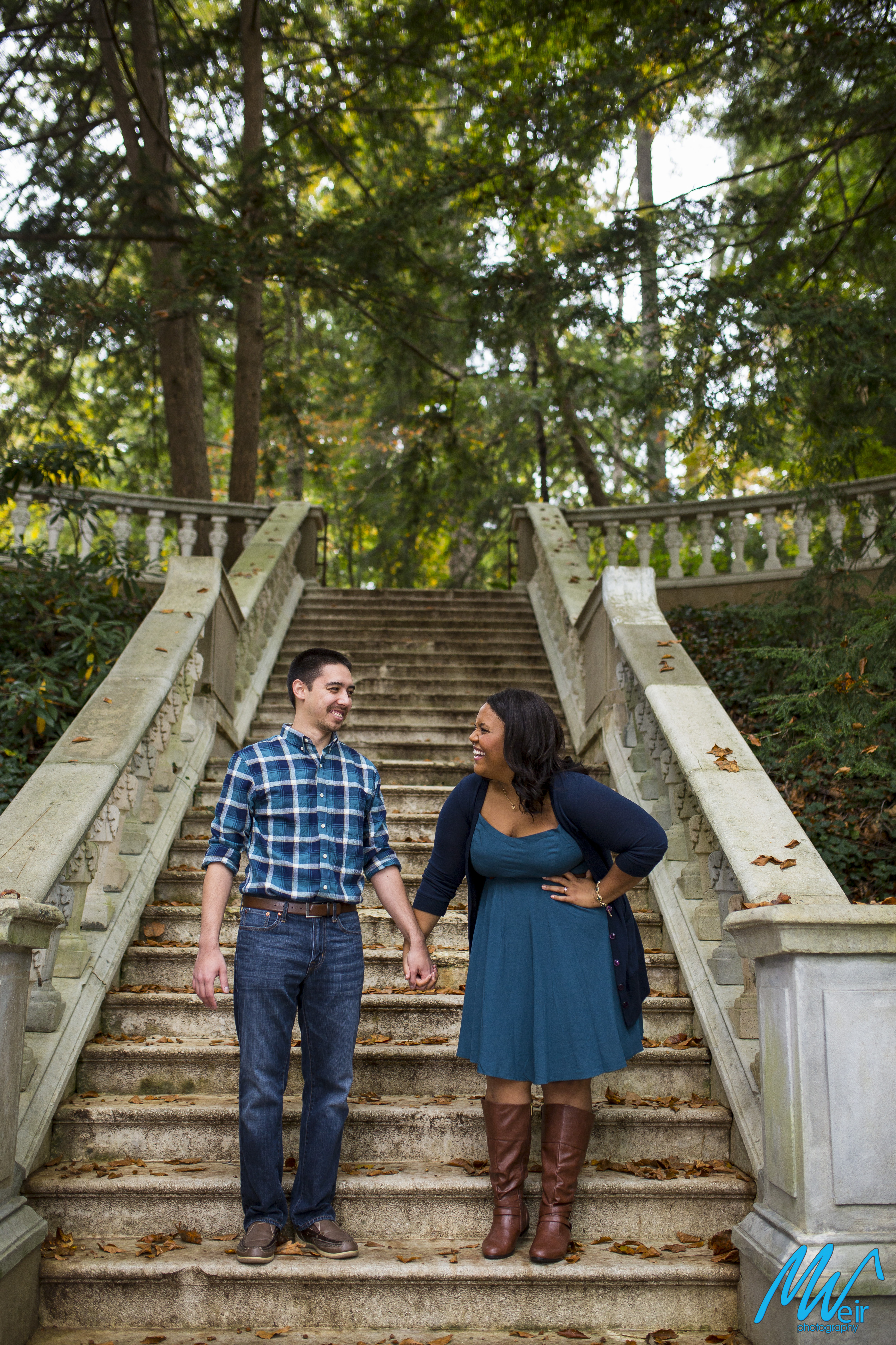 couple laughing in front of stone grand stairs