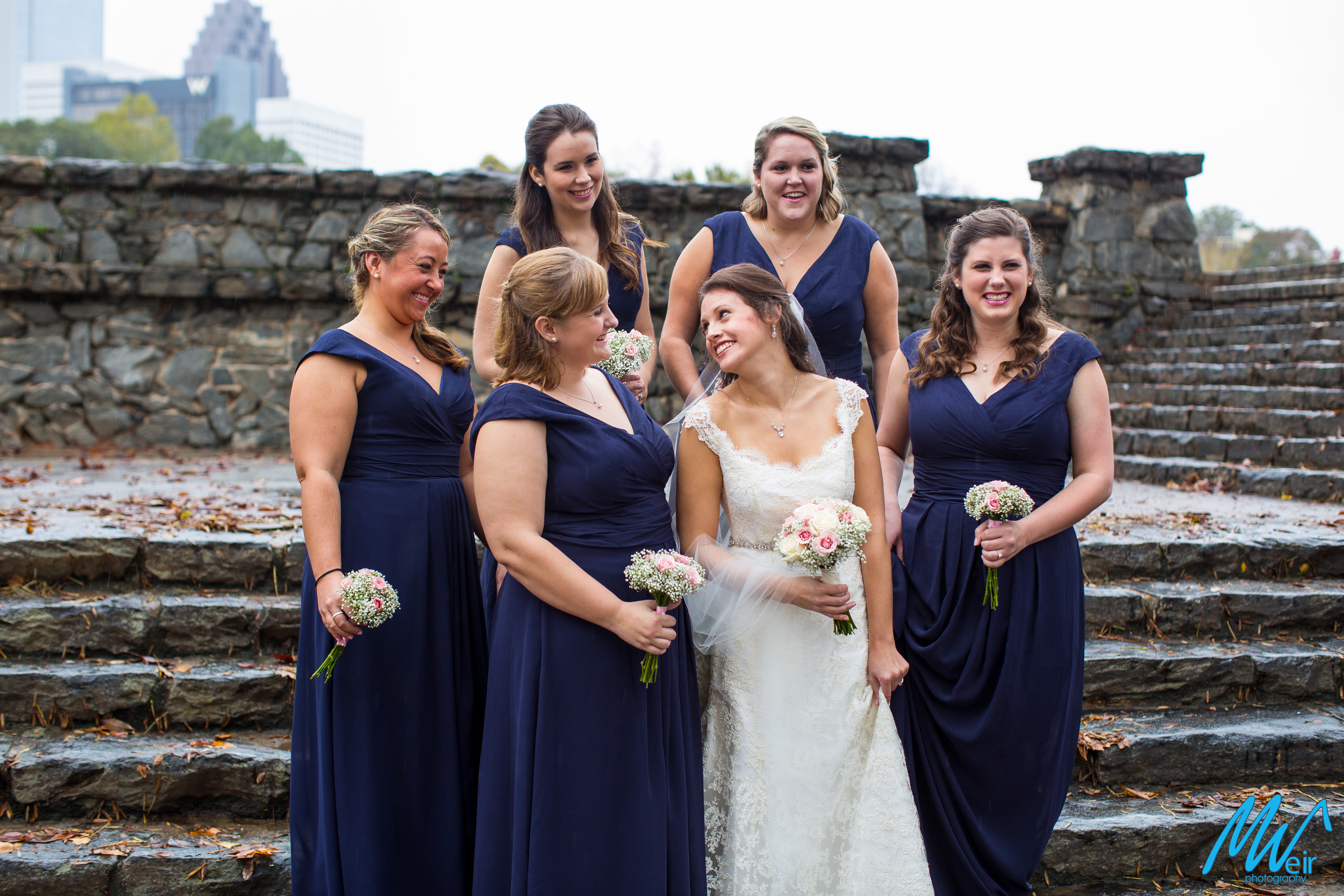bride with bridesmaids in long navy dresses