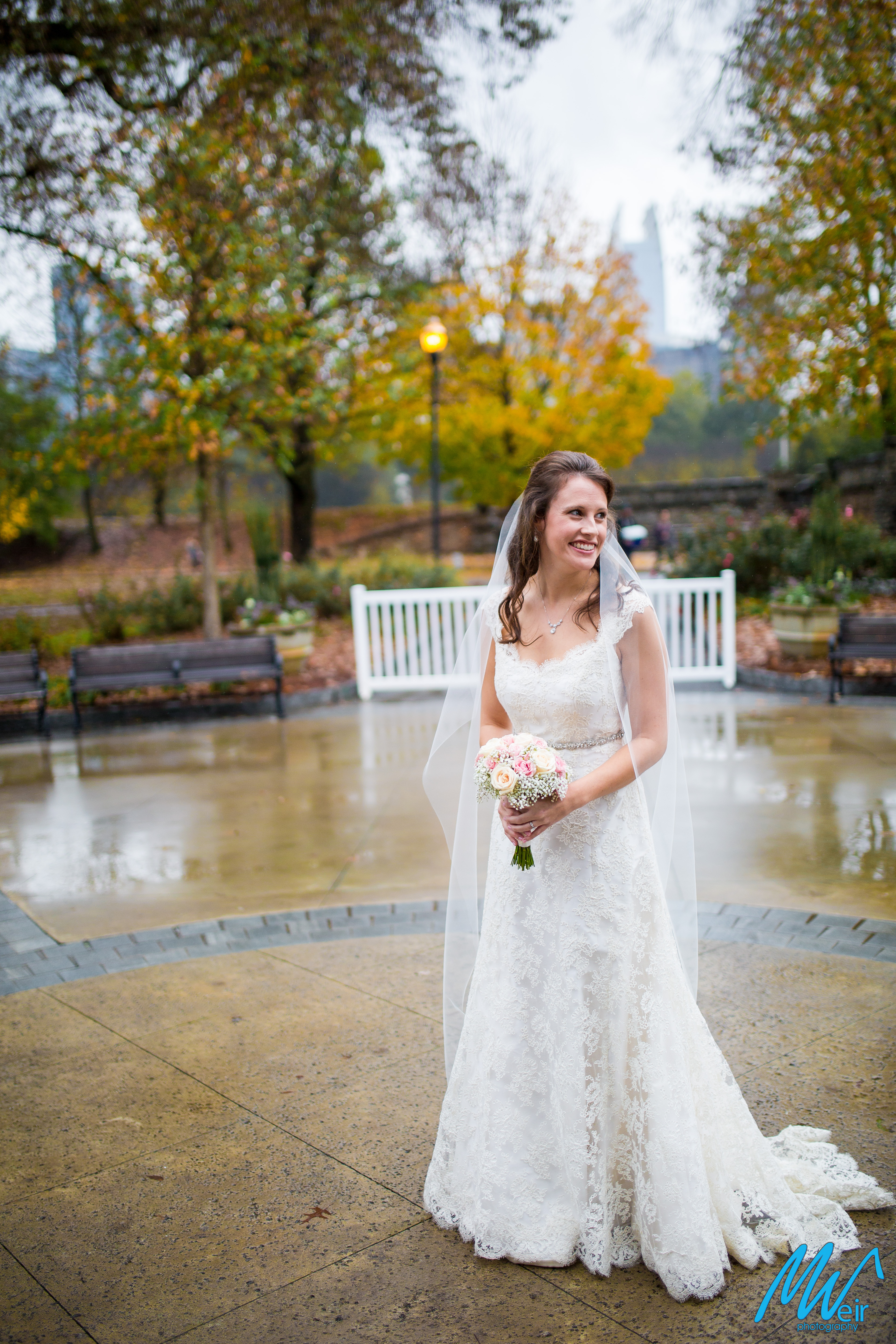 bride standing in middle of rotunda with fall leaves behind her
