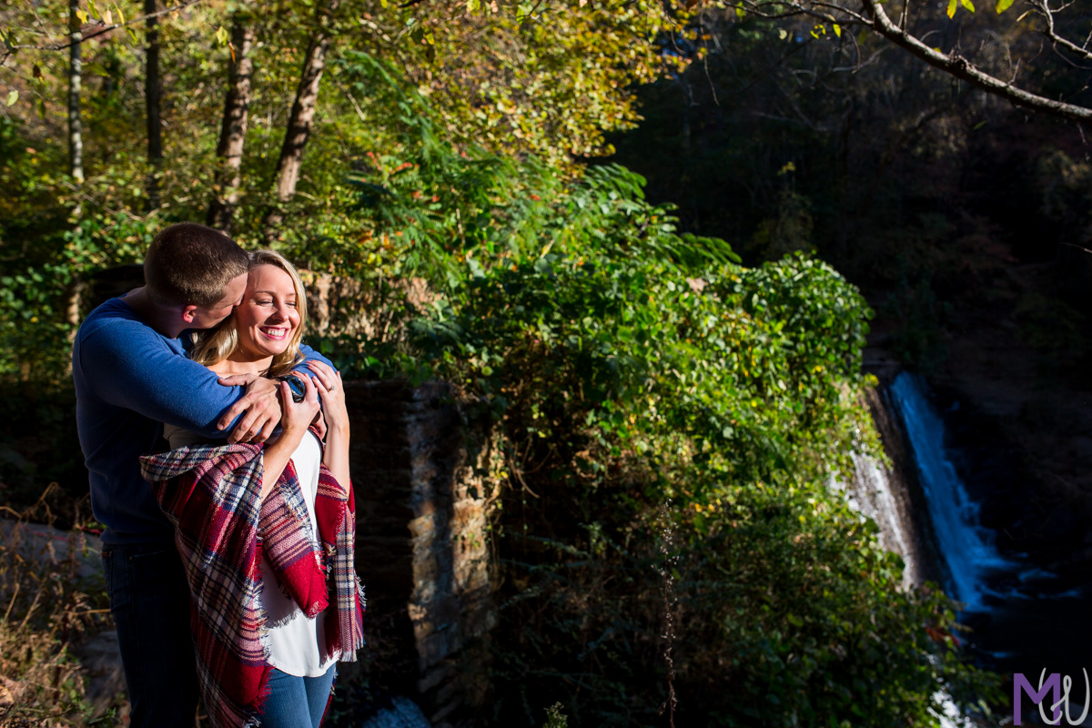 couple in dramatic light in front of a waterfall