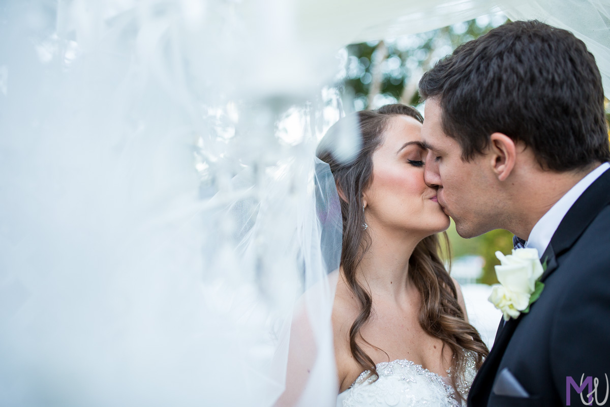 bride and groom kissing through a veil